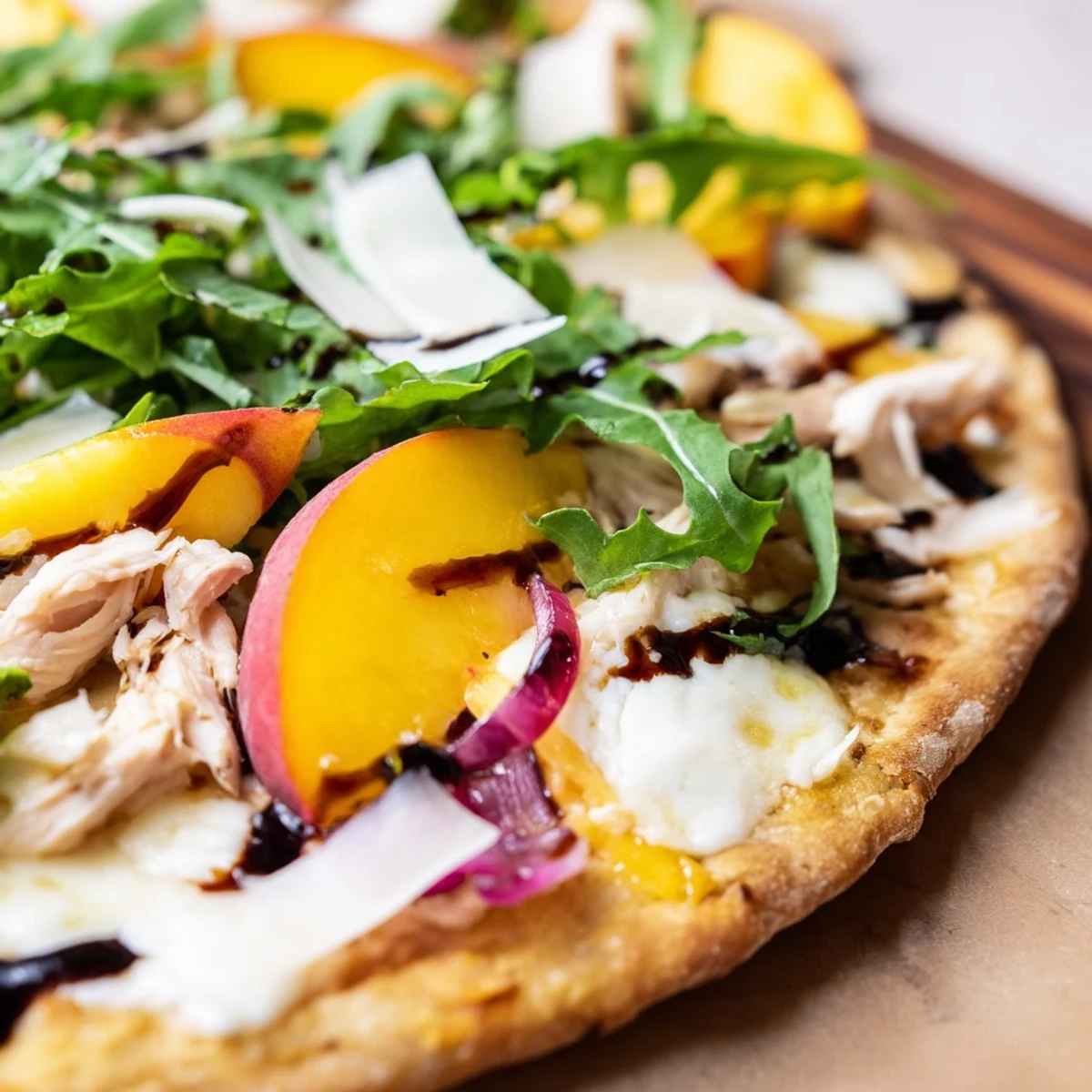 Summer chicken peach ricotta pizza featuring bubbling cheese and peppery arugula on crisp crust