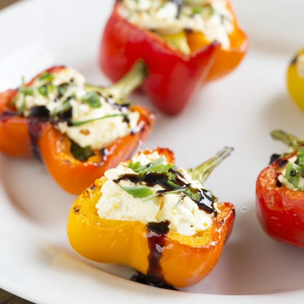 Golden mini peppers filled with creamy herbed goat cheese after roasting to tender perfection on a baking sheet