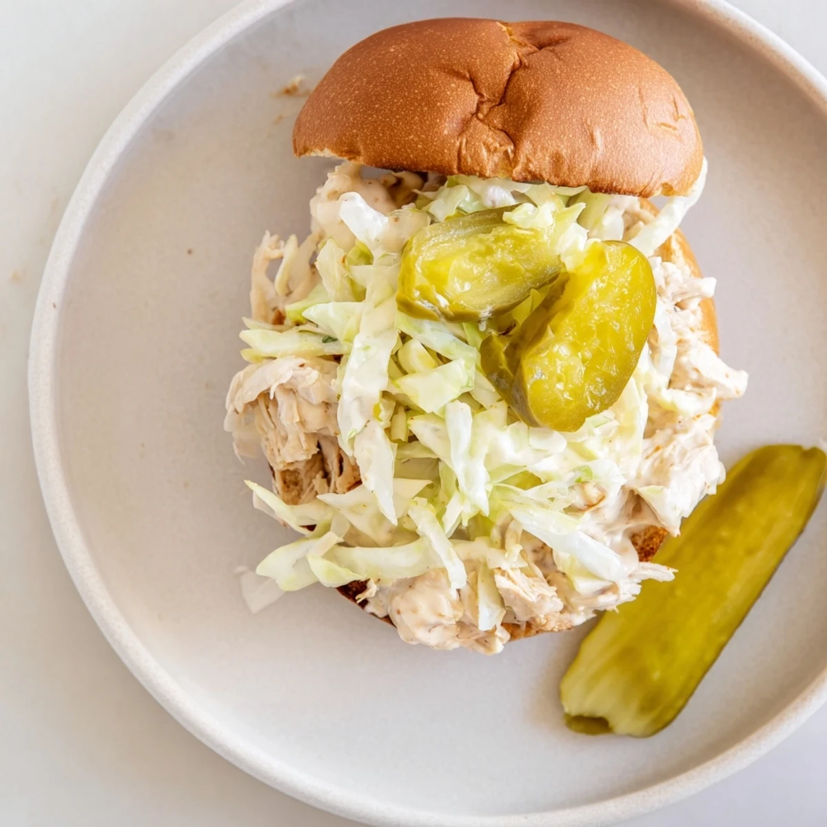 Juicy smoked chicken pieces in mayonnaise-based barbecue sauce topped with crunchy slaw on bread