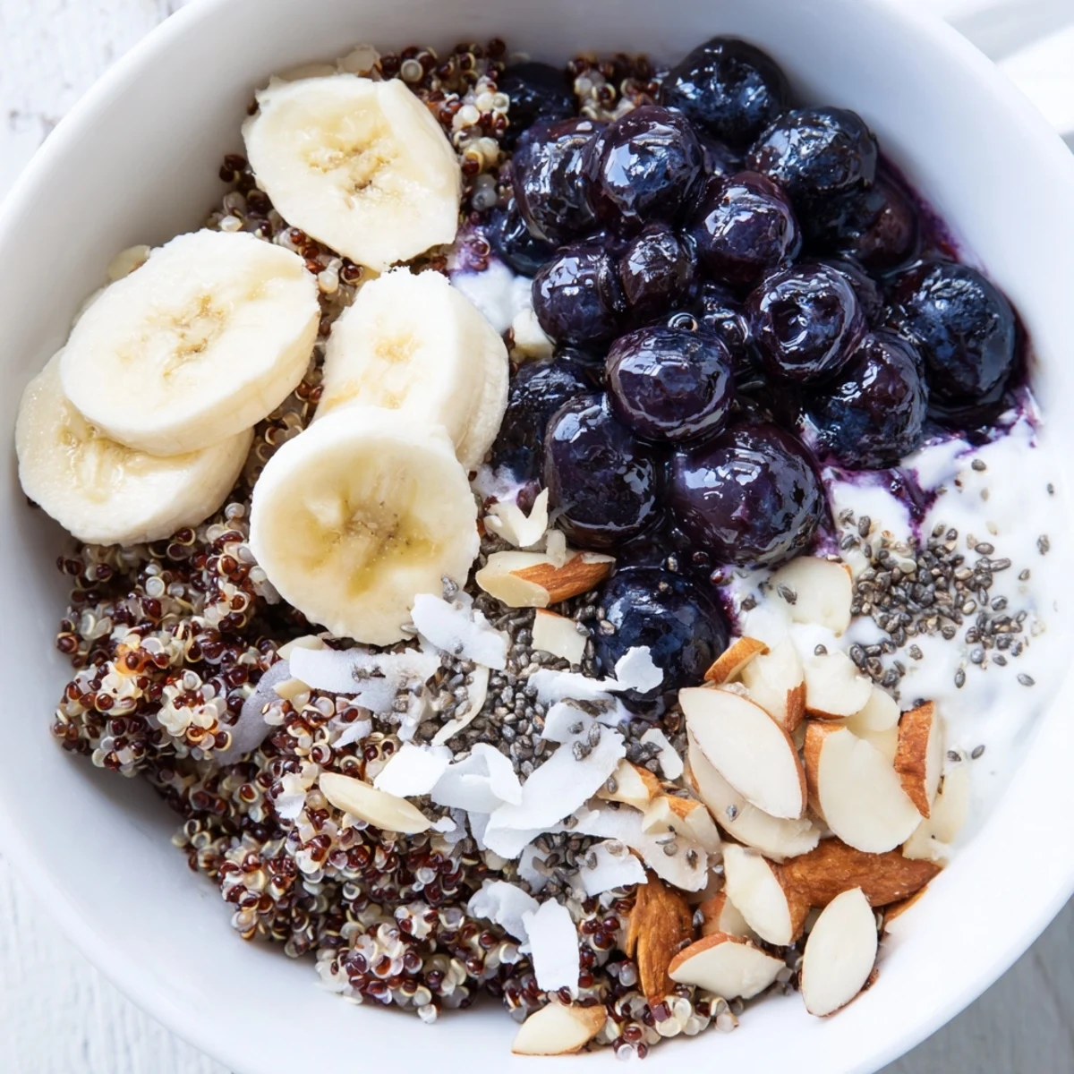 Colorful morning blueberry quinoa breakfast bowl featuring yogurt and sweet maple syrup drizzle