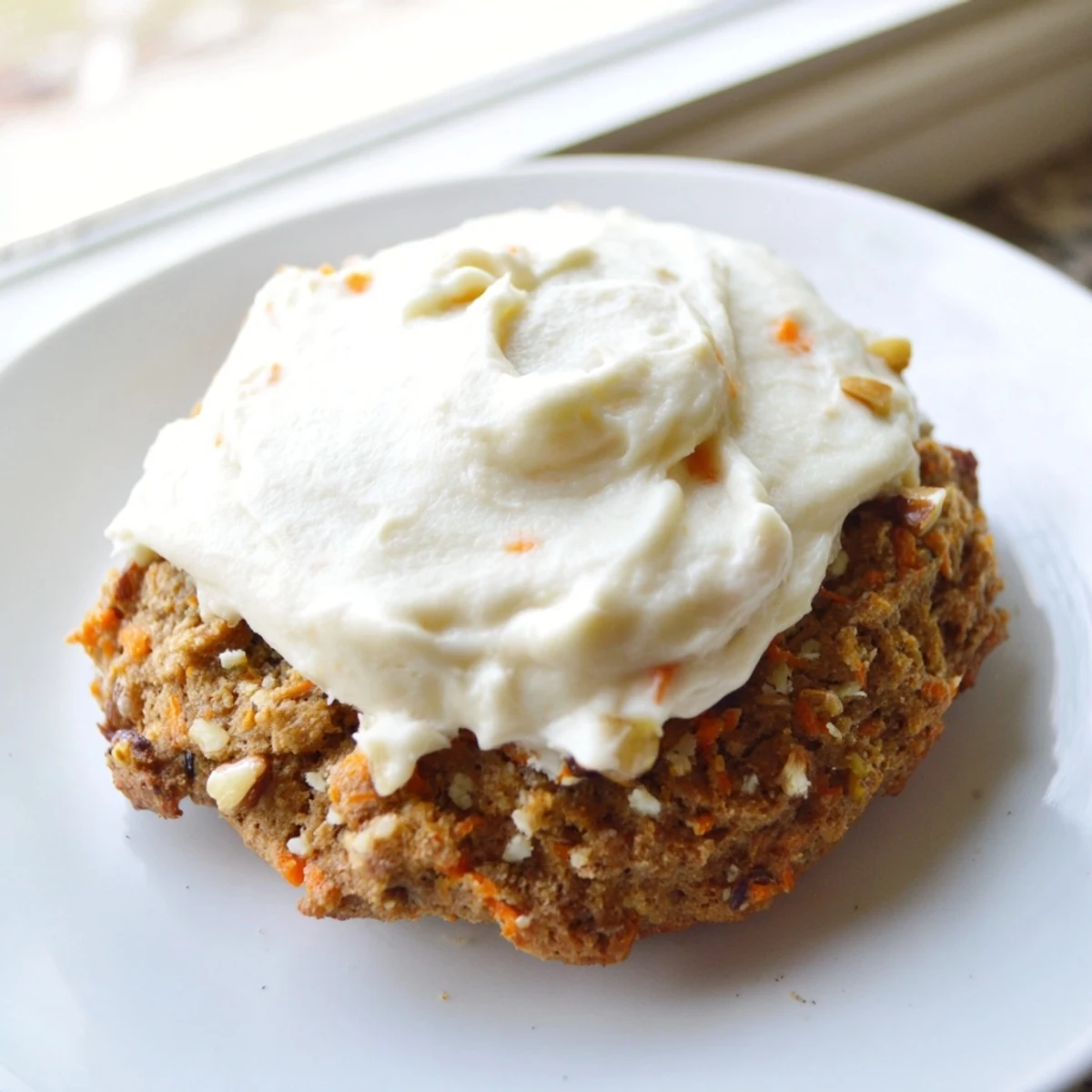 Chewy spiced carrot cake cookies topped with thick cream cheese frosting and chopped walnuts