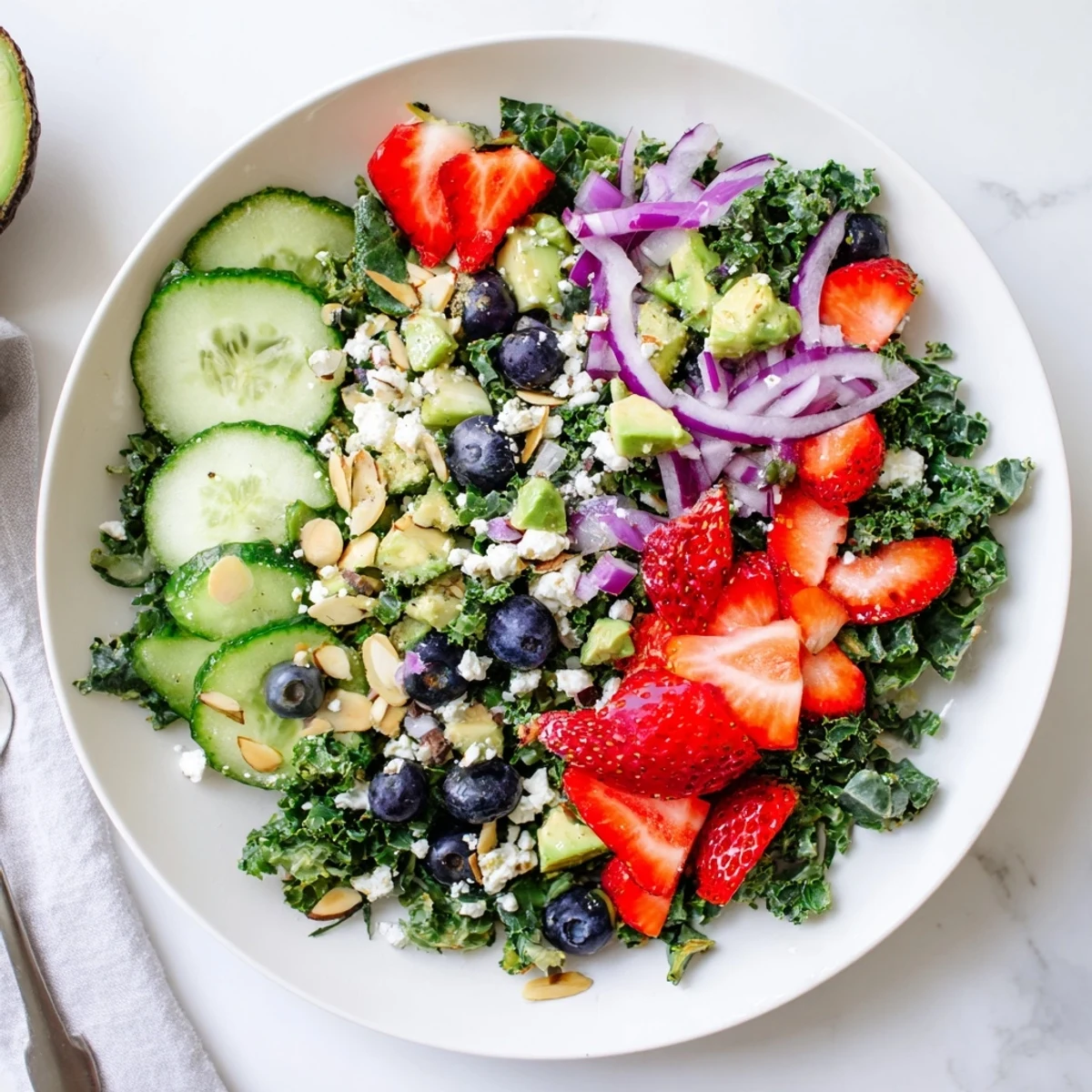 Summer kale salad drizzled with lemon-honey vinaigrette in a wide shallow bowl