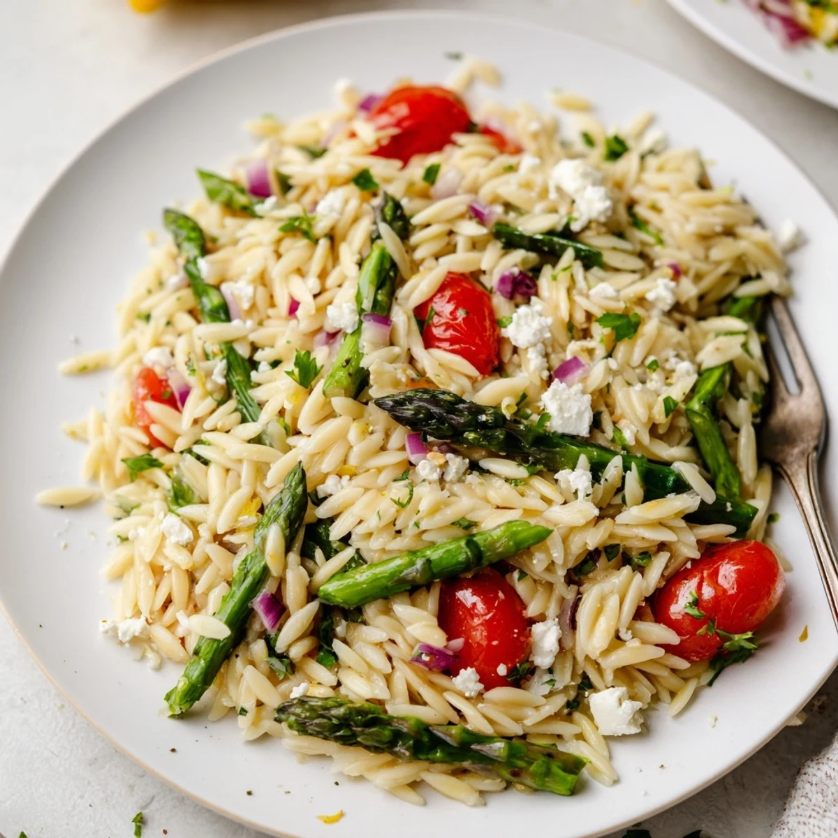 Asparagus Orzo Salad With Lemon Vinaigrette featuring tender asparagus, juicy tomatoes, crumbled feta.