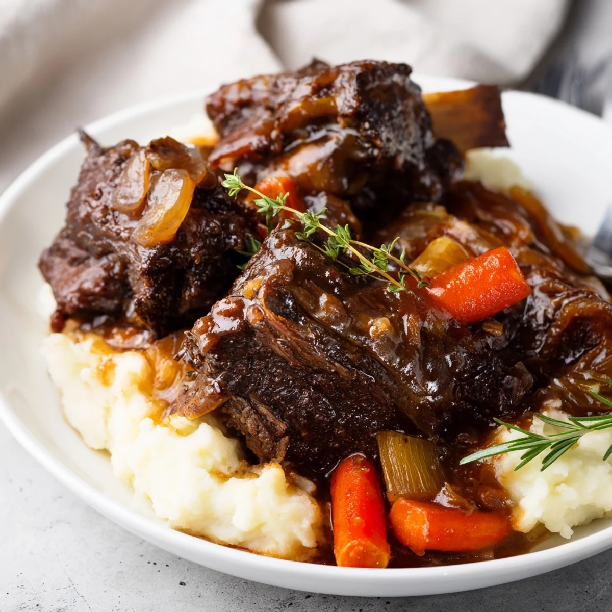 Serve Slow Cooker Beef Short Ribs over creamy mashed potatoes with savory gravy