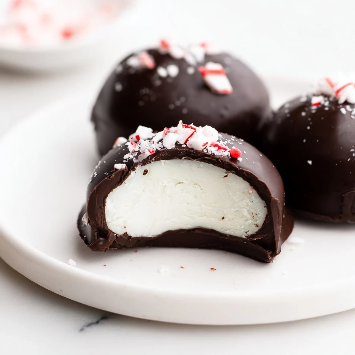 Peppermint Patties glistening with dark chocolate, stacked on parchment for gifting
