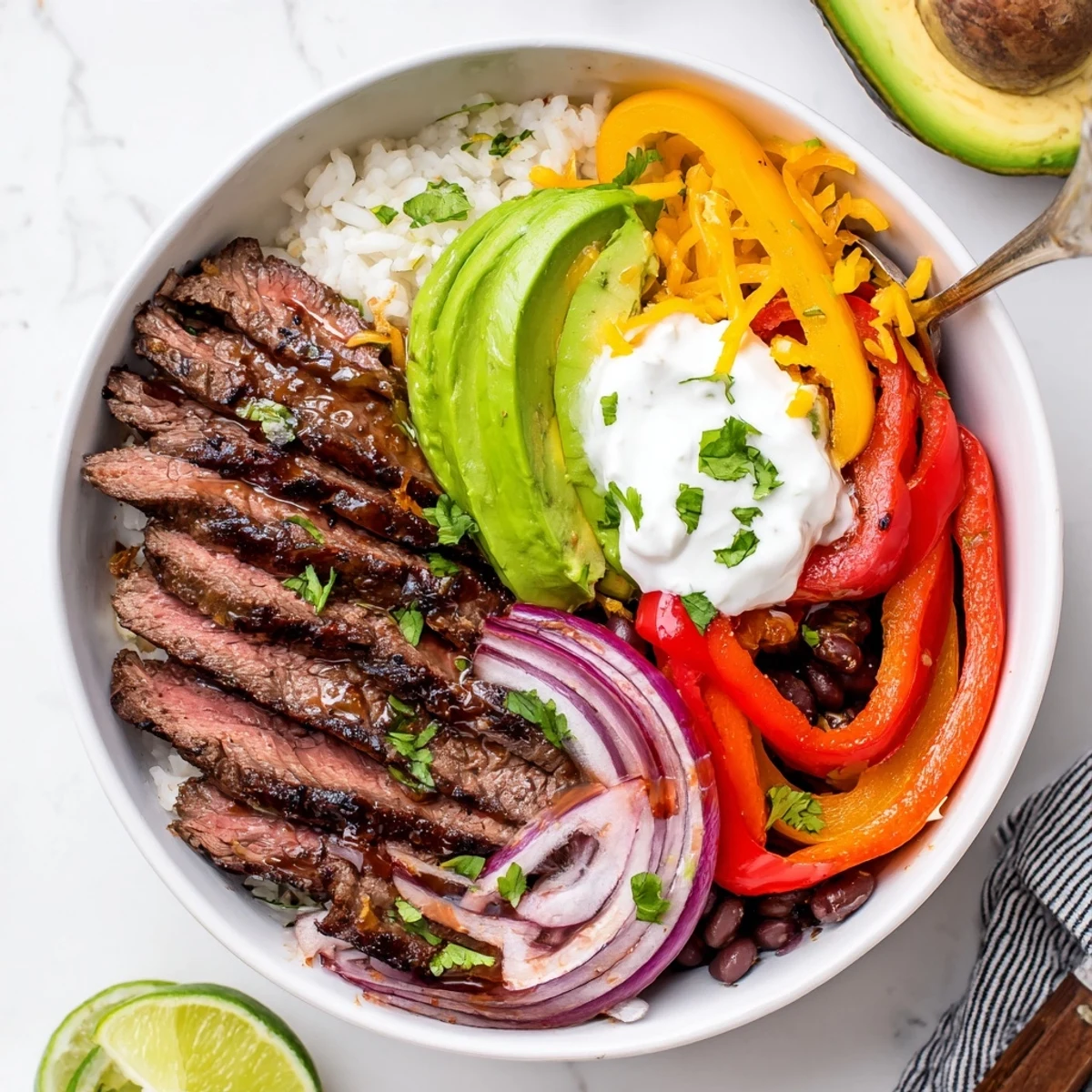 Steak Fajita Power Bowls with seared steak, colorful peppers, lime wedge  