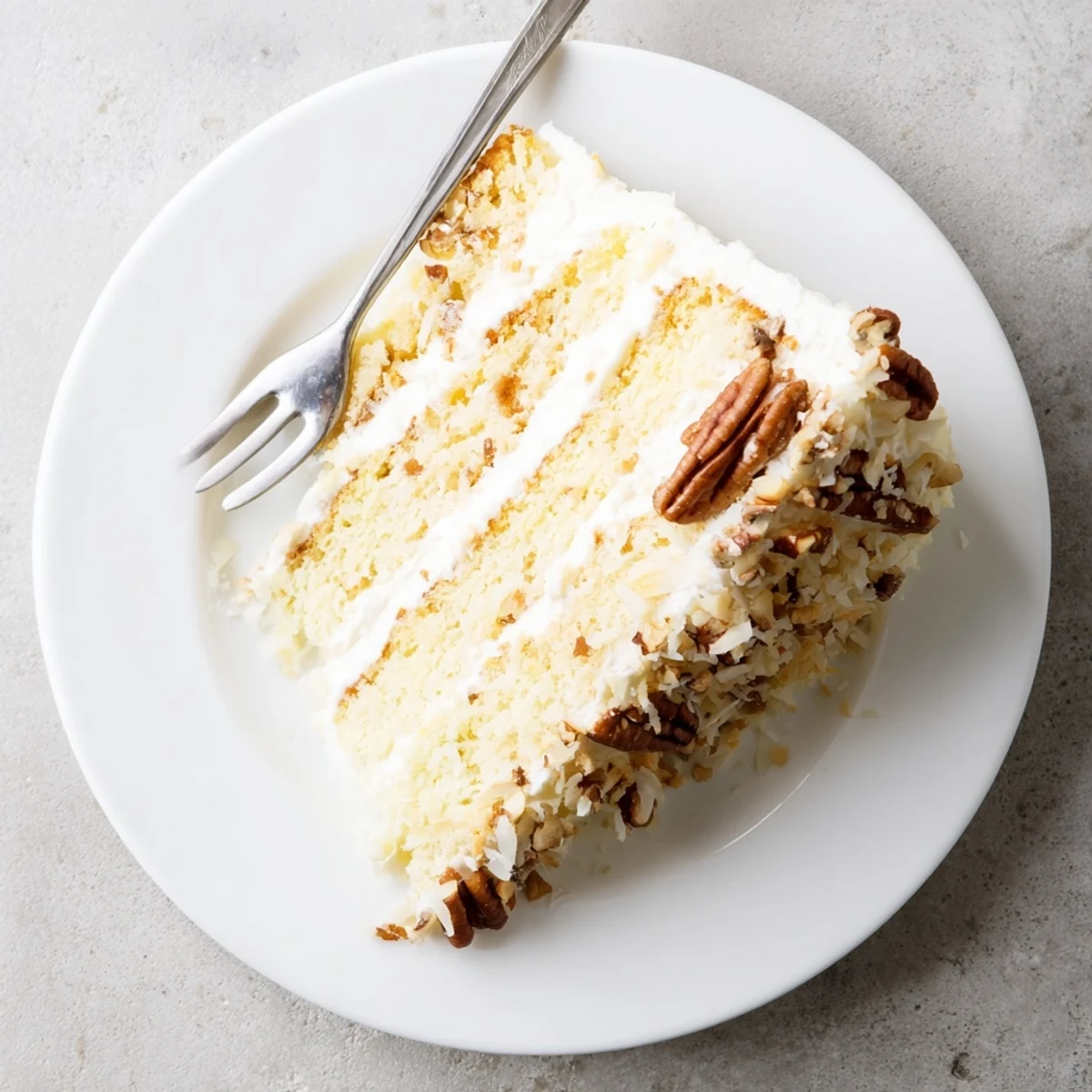 Homemade Quick Italian Cream Cake with fluffy cream cheese frosting and toasted pecan coconut topping