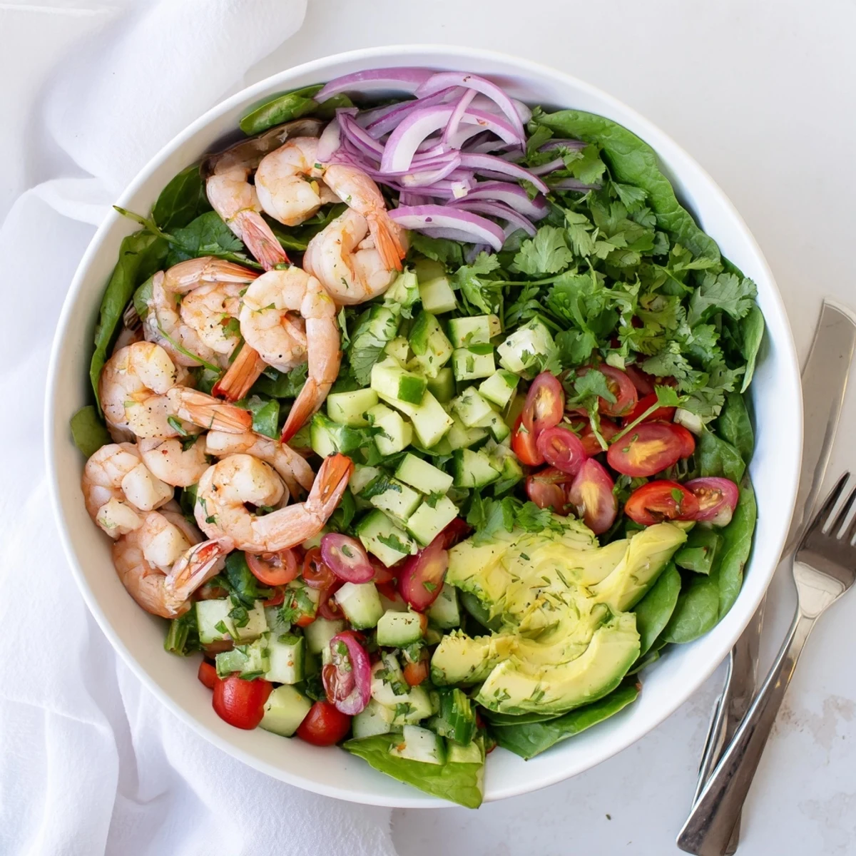 Colorful shrimp avocado salad recipe with pink shrimp, green avocado, and fresh vegetables drizzled with citrus dressing