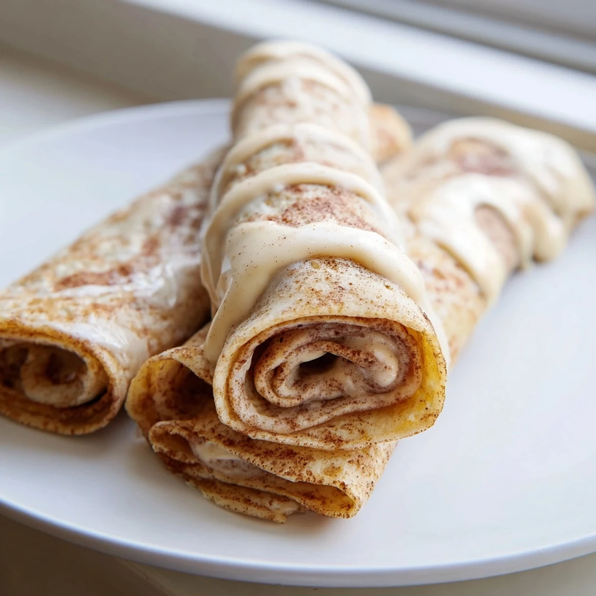 Thin cinnamon roll protein crepes swirled with spiced brown sugar filling and plated beautifully
