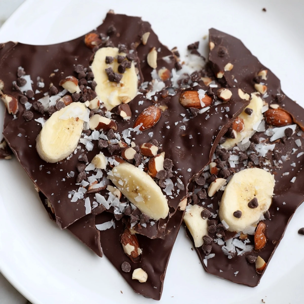 Glossy chocolate banana bark topped with crunchy roasted nuts and flaky sea salt