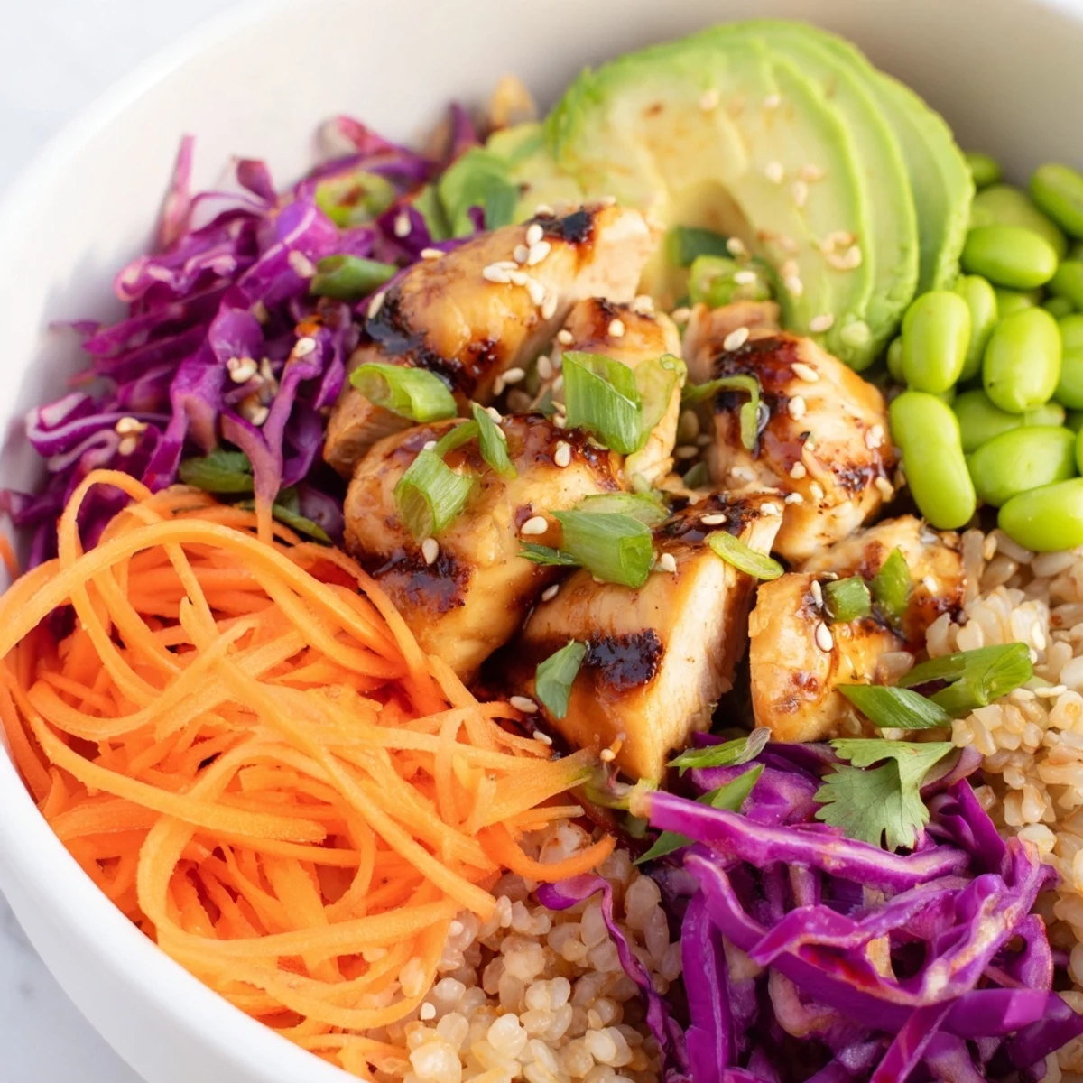 Fresh Asian Inspired Chicken Power Bowl garnished with sesame seeds cilantro and lime