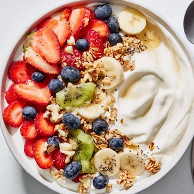 Vibrant yogurt fruit bowl drizzled with honey and loaded with seasonal berries